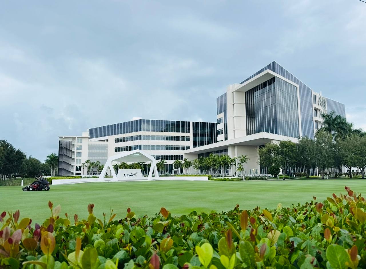 The Arthrex headquarters buildings in Naples, Florida, seen across a lawn.