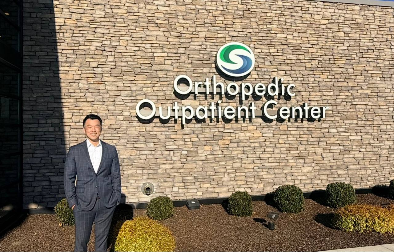 Dr Bob Jang standing in front of the Orthopedic Outpatient Center in Medford, Oregon.